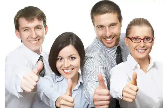 Smiling diverse professionals giving thumbs up, representing trusted insurance services at Nick Godfrey Insurance Inc. in a professional business setting.