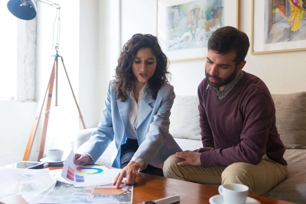 Professional insurance consultation between a female agent and a male client discussing coverage options in a modern office setting.