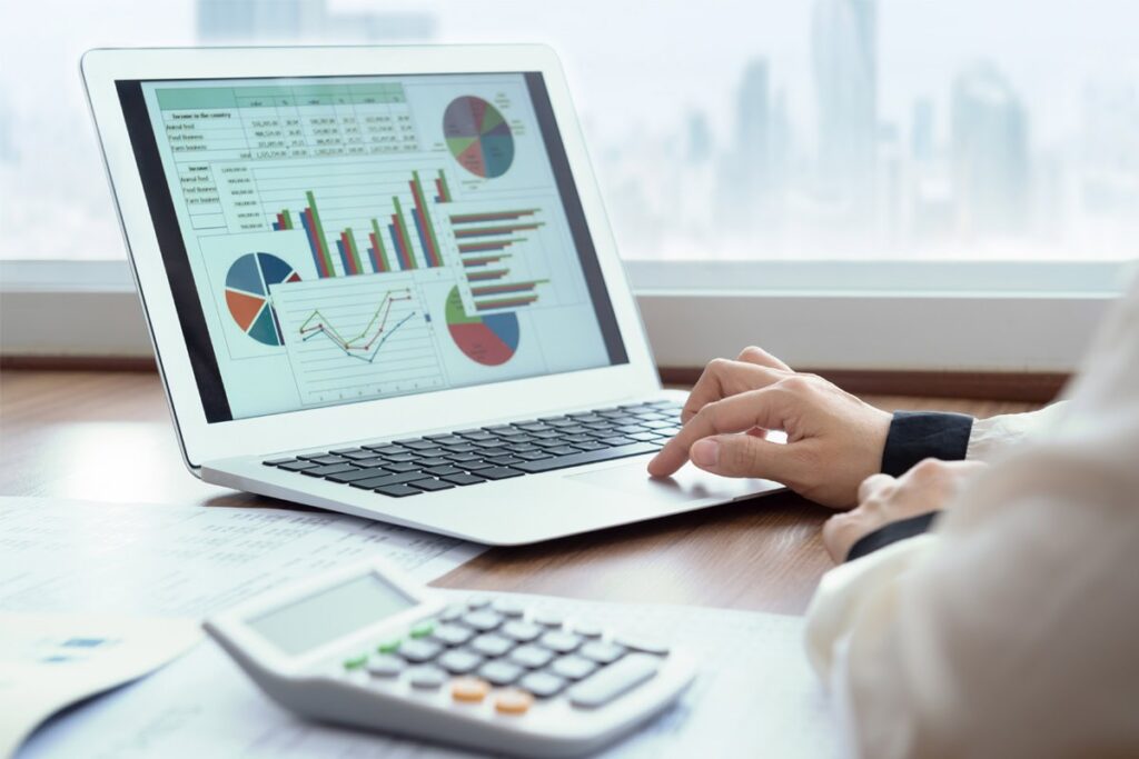 Analyzing financial data and insurance reports on a laptop for insurance service optimization.